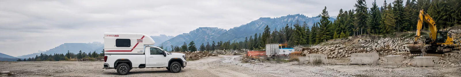 Mobile Treatment Centre truck on an industrial job site in BC with excavator and mountain backdrop